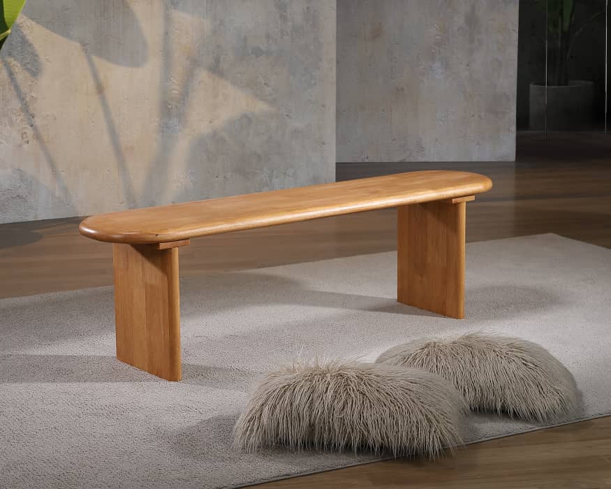 Solid wood bench with a rounded top on a grey rug