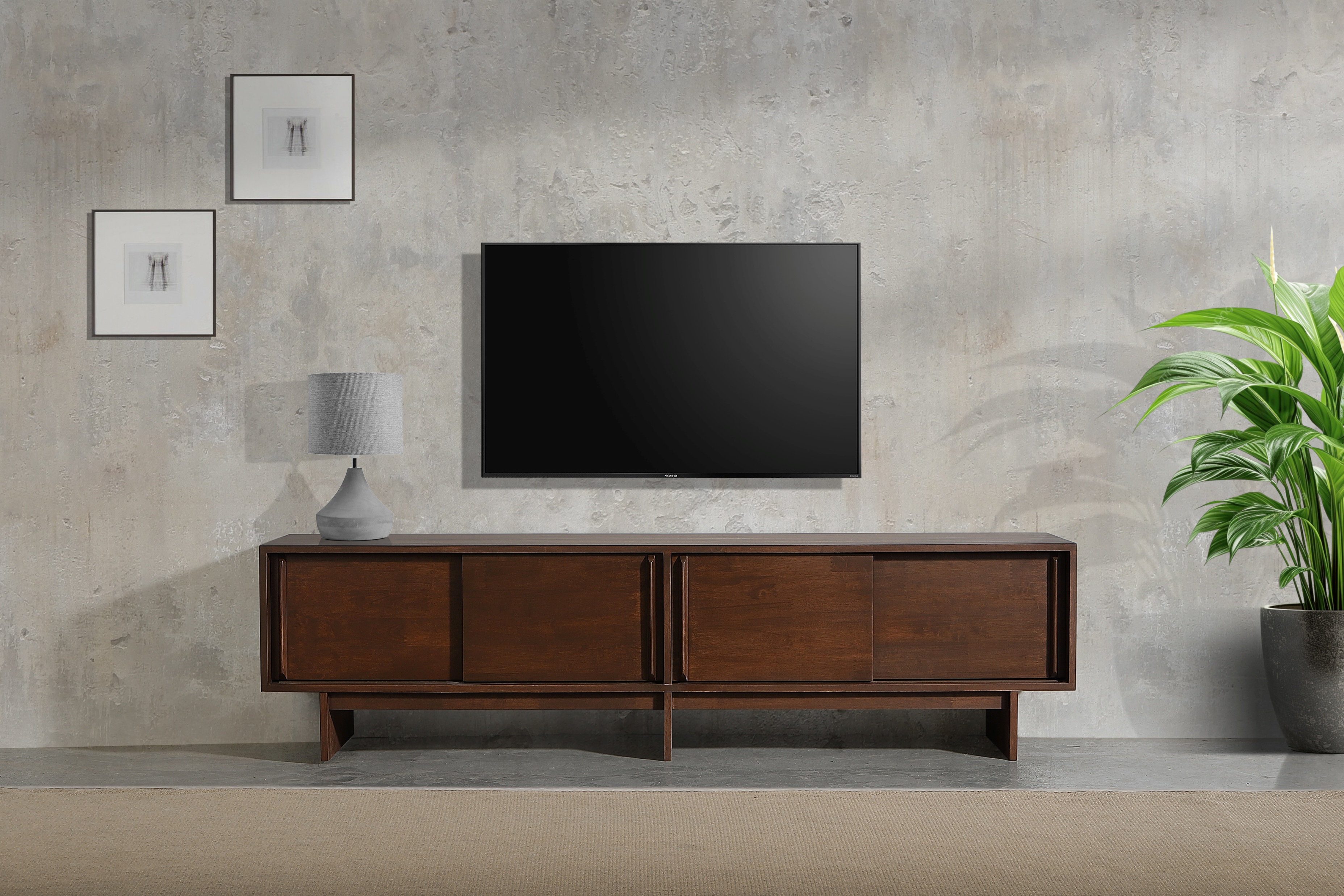 Dark solid wood TV console with panelled doors against a concrete wall